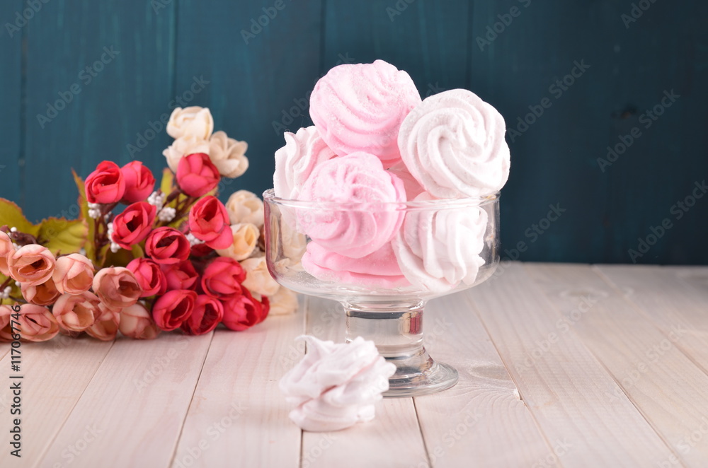 Zefir or marshmallow roses on a wooden stand as part of sweet dessert table or candy bar. Wedding pa