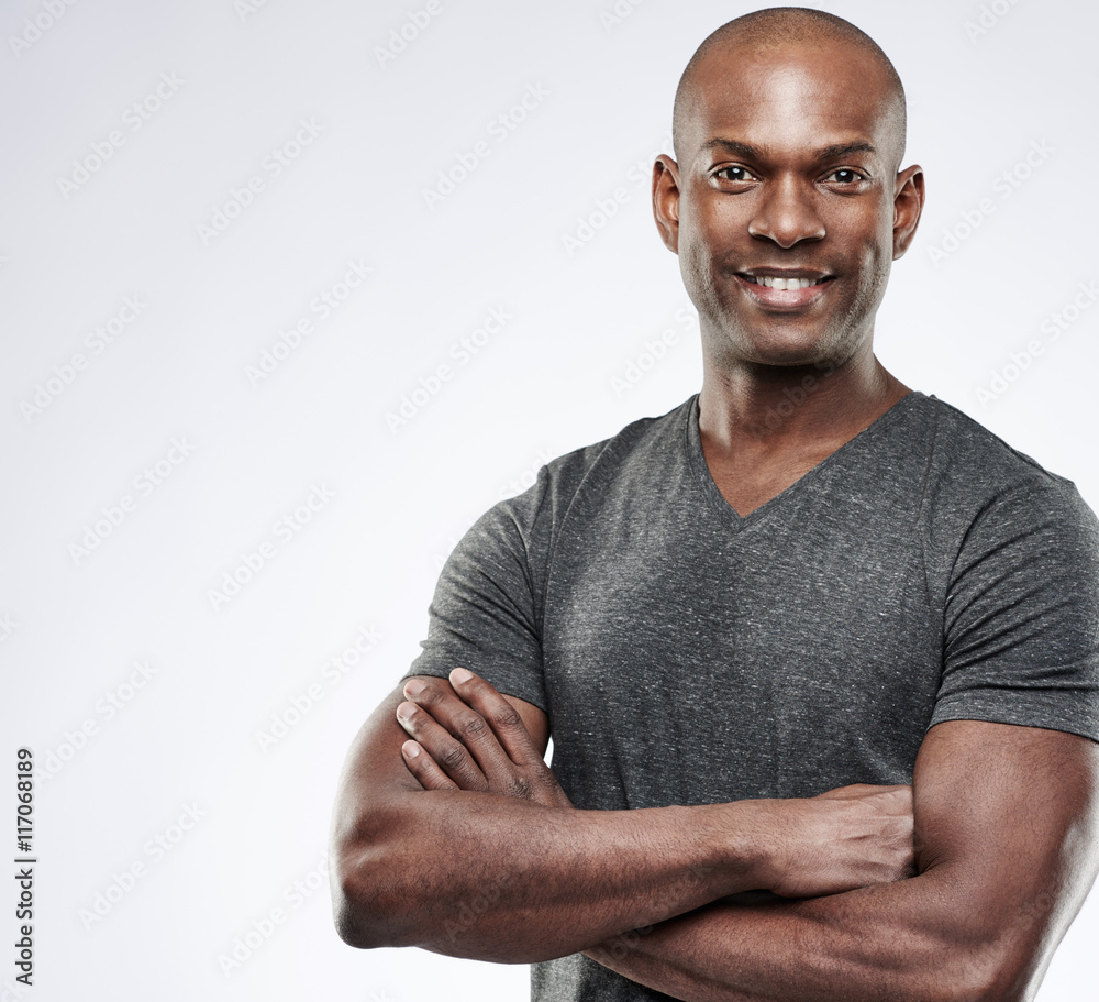 Cute muscular grinning man with folded arms