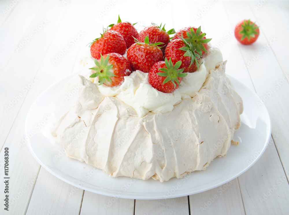 Pavlova cake with strawberry on rustic background