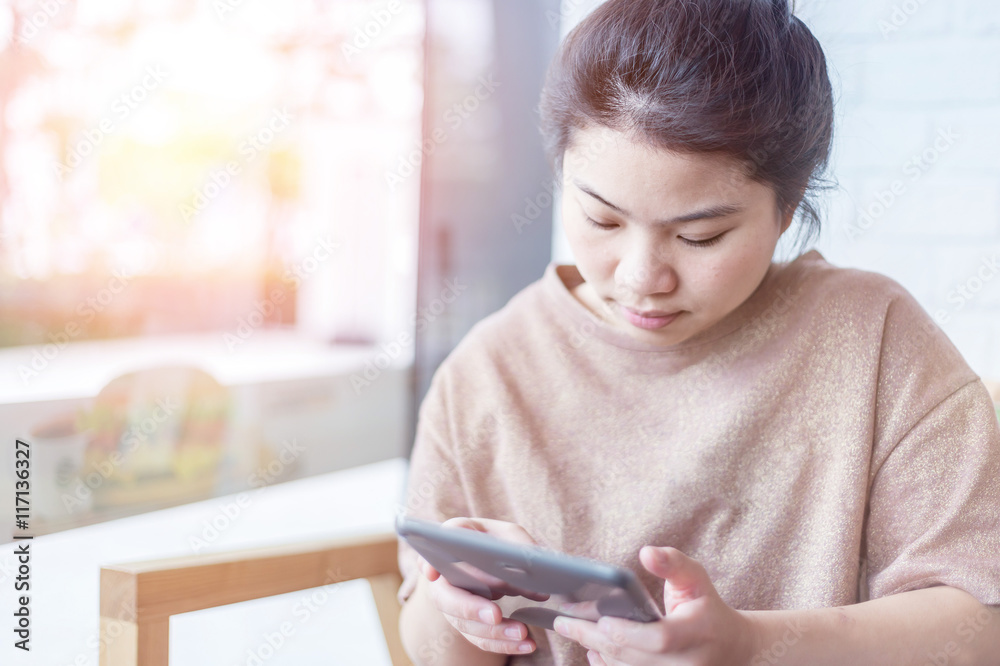 Young asian woman using the phone in coffee shop