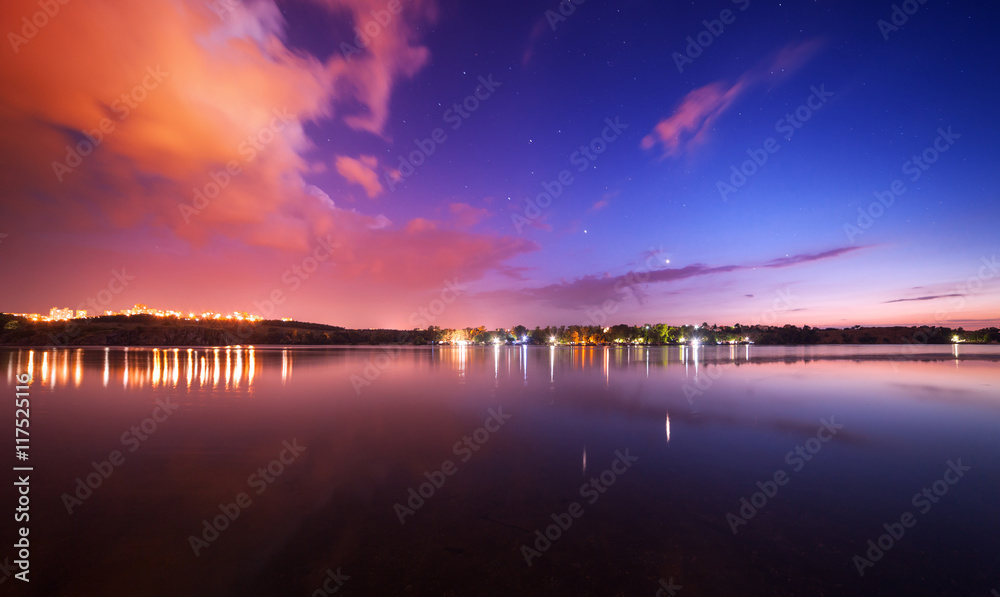 Beautiful night sky at the river with stars and clouds