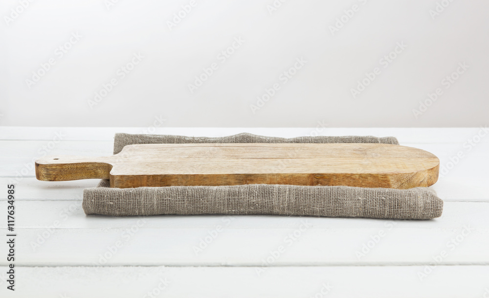 Empty cutting board on white wooden table.