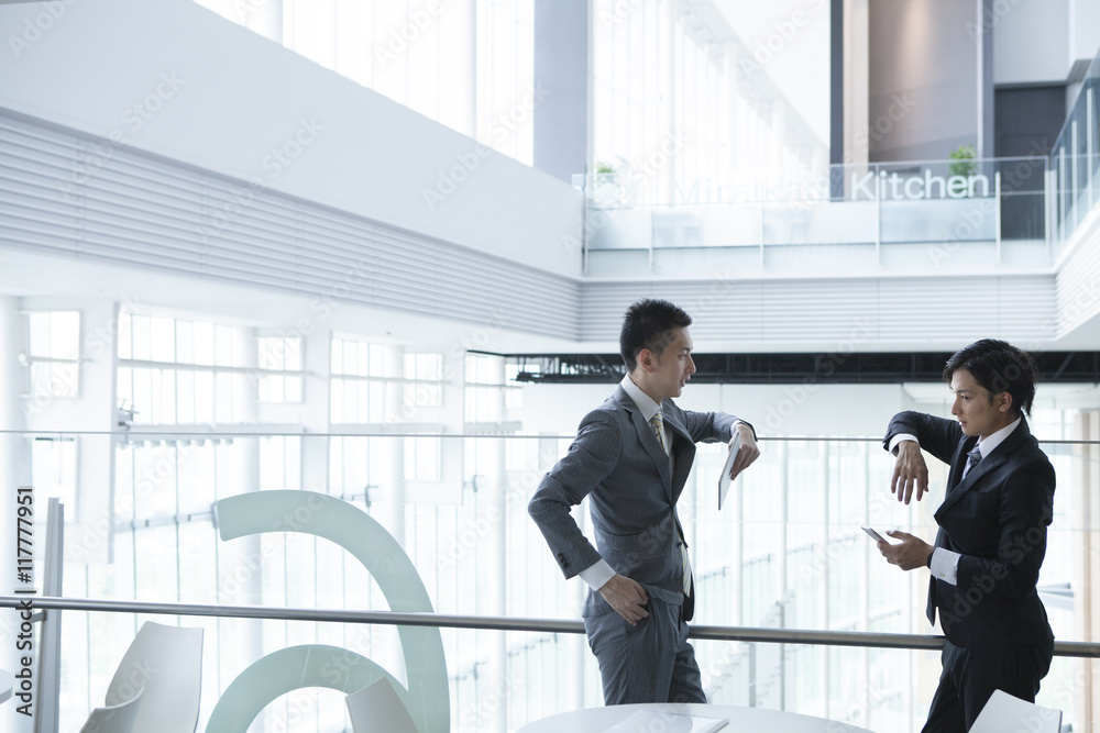 Young businessman has been the stand talking while looking at the smartphone