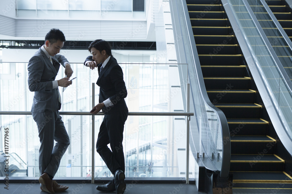 Young businessman has been the stand talking while looking at the smartphone