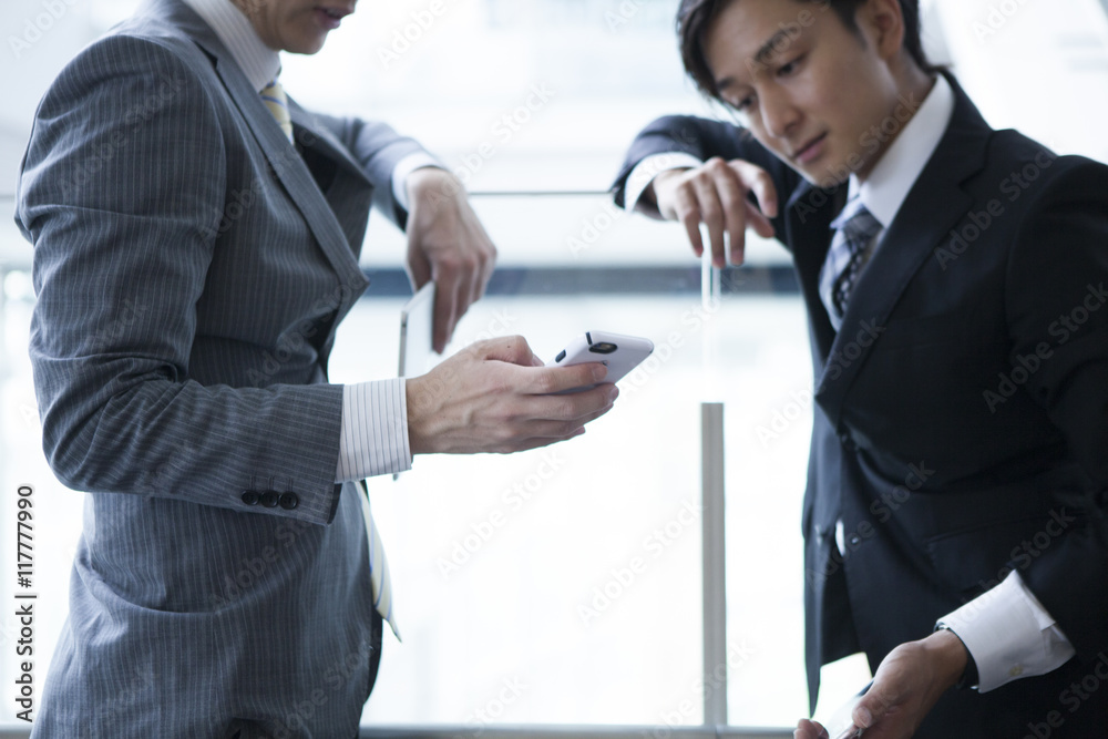 Young businessman has been the stand talking while looking at the smartphone