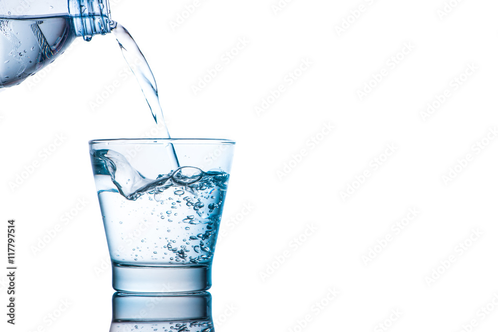 Drinking water is poured into a glass from bottle