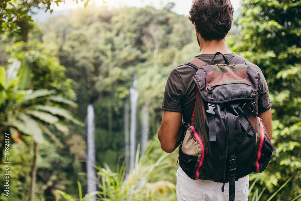 欣赏瀑布的年轻男性徒步旅行者