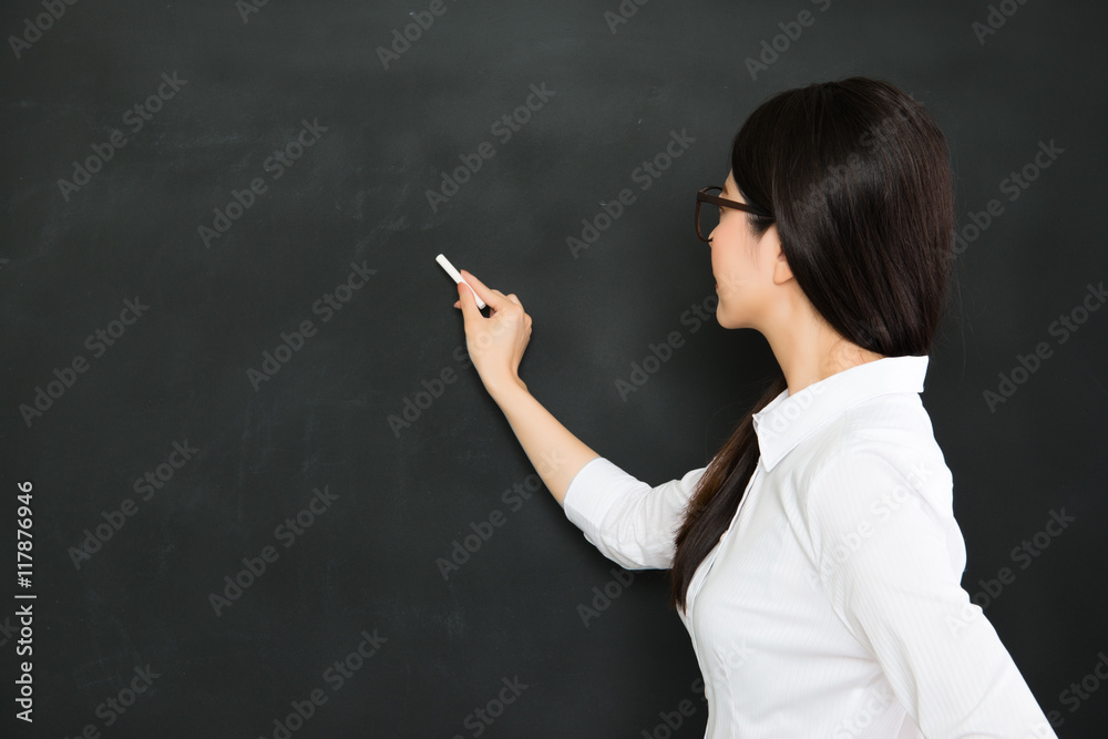 A good asian teacher writing on blackboard with chalk