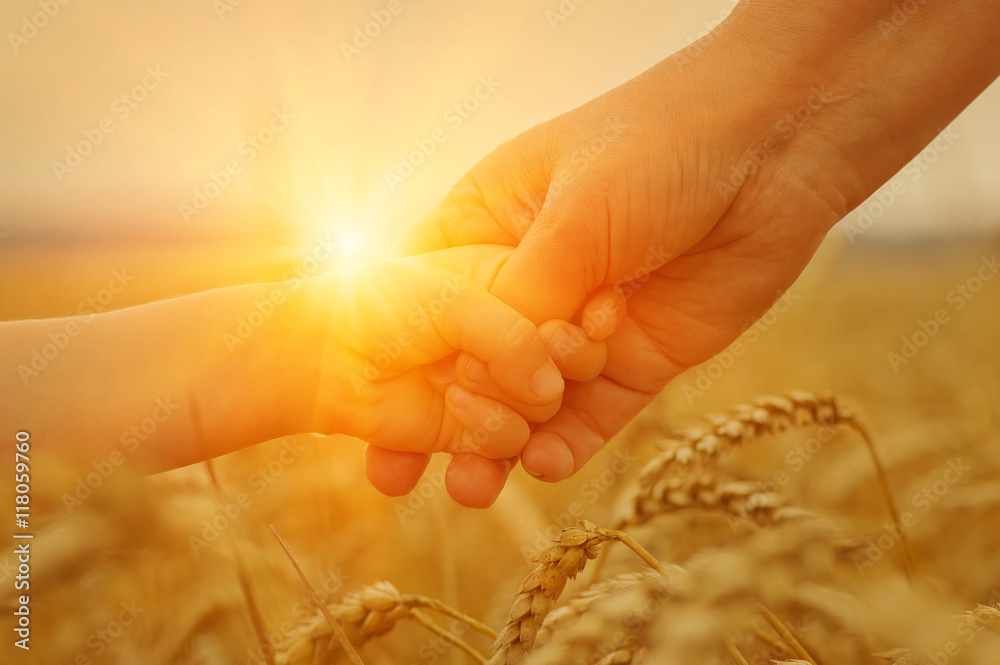 Hands of mother and daughter on sun