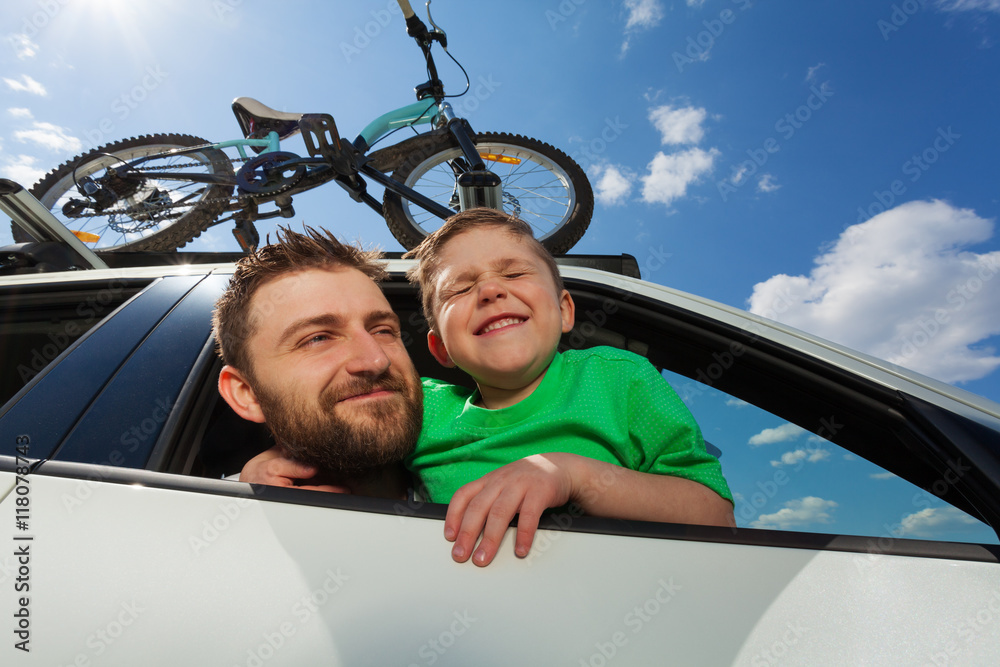 Happy travelers looking out the window of a car