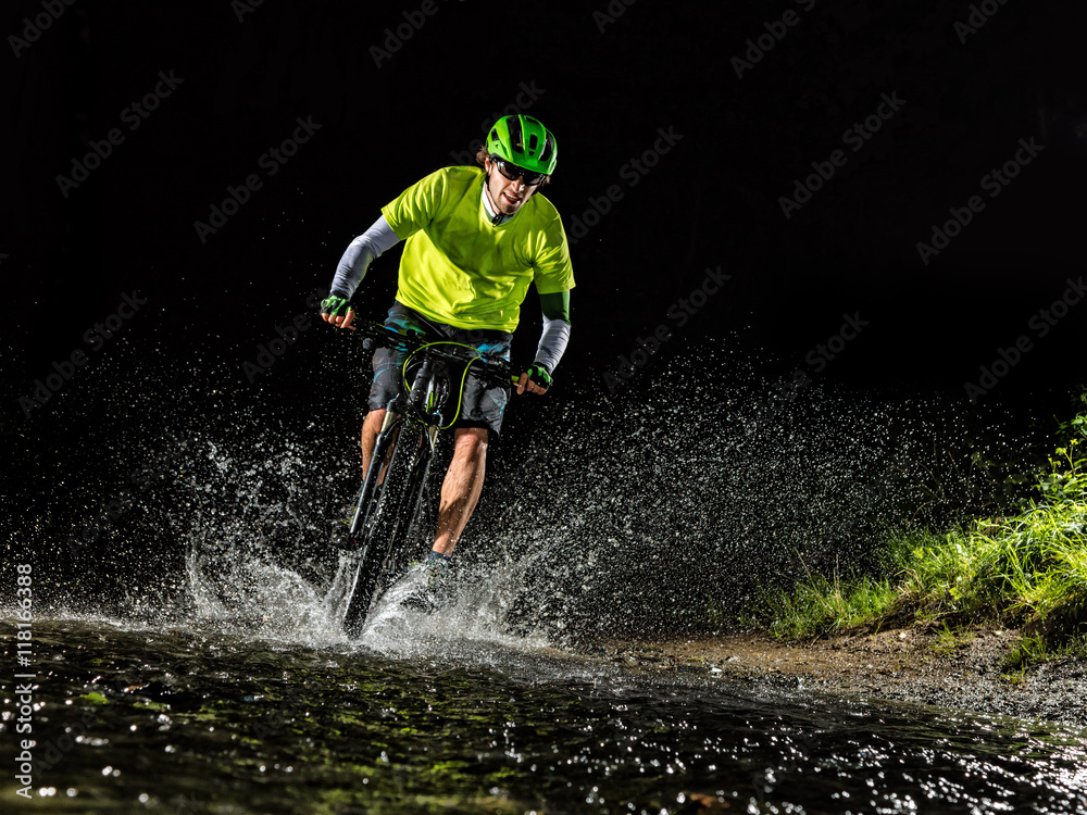 Mountain biker riding in forest stream