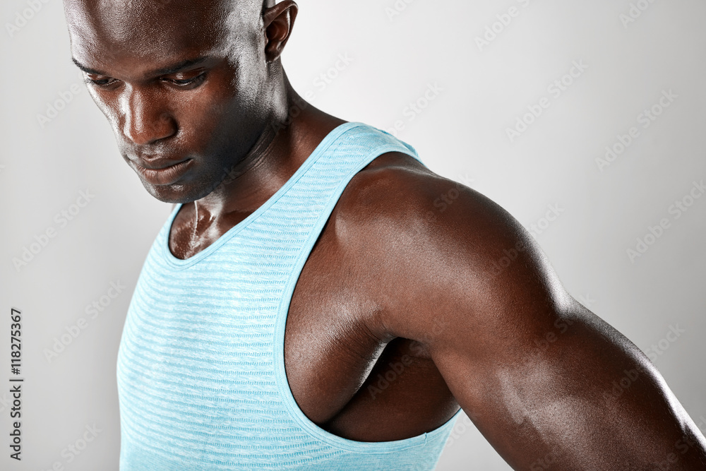 Muscular young african man looking down