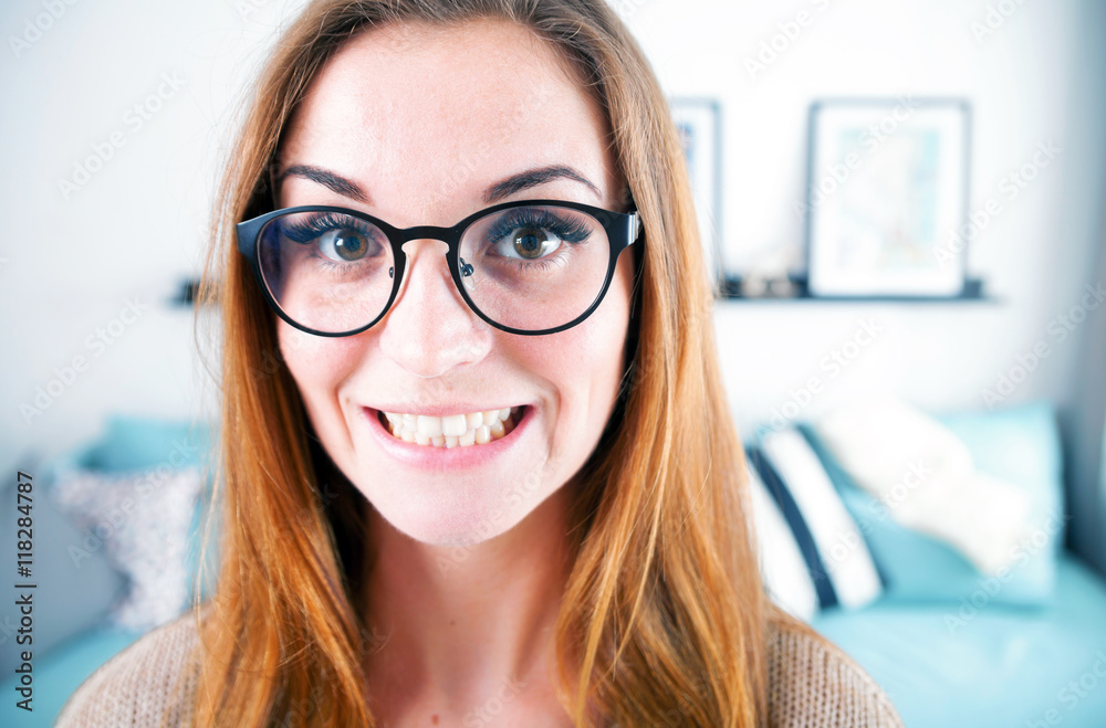 Portrait of nerd woman with big eyeglasses at home