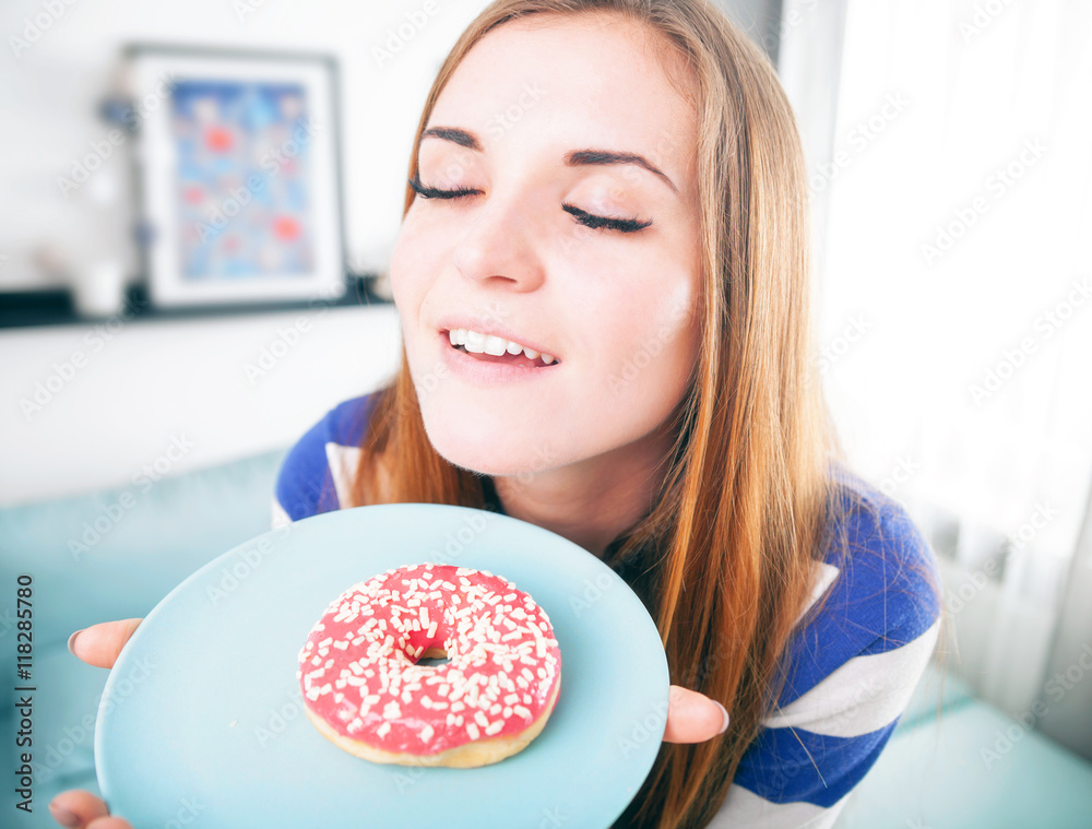 Woman at home smelling fresh donut