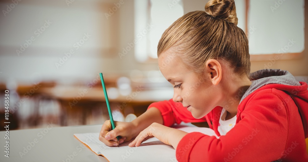 Composite image of cute girl writing in a book