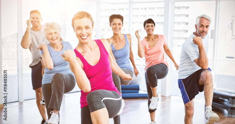 Smiling people doing power fitness exercise at yoga class