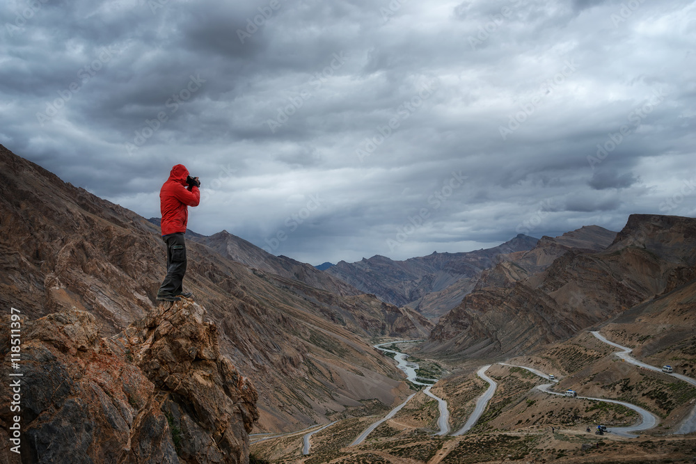 Photographer in red jacket on the hill