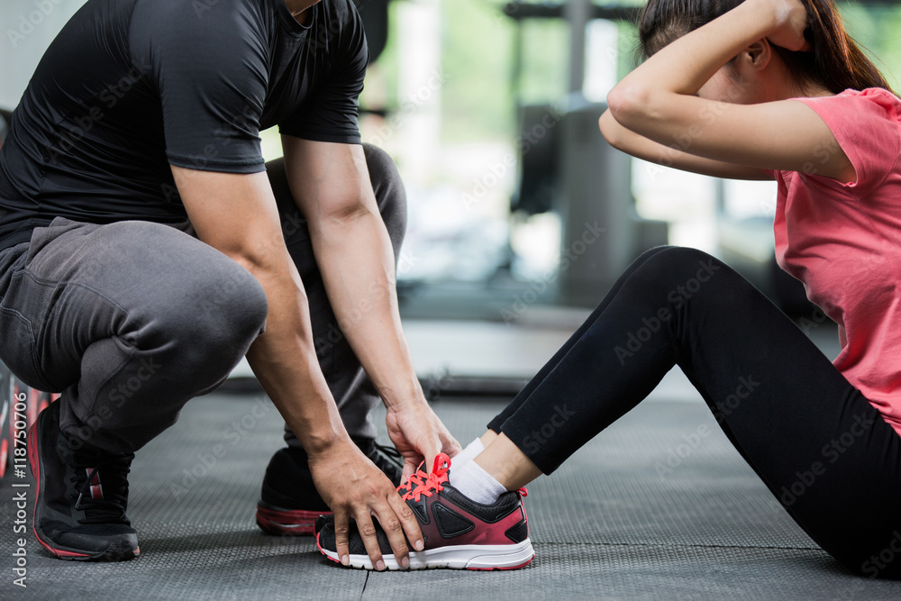 Trainer holding a woman in the leg exercise by Sid-ups.