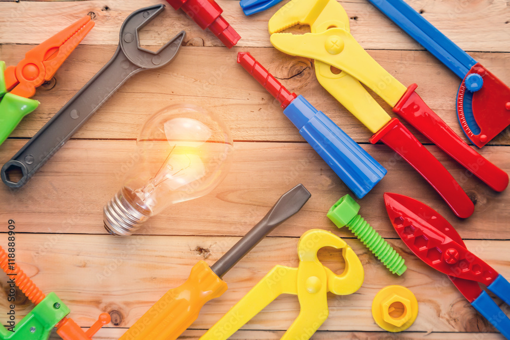 tools and instruments toys with light bulb on wood texture