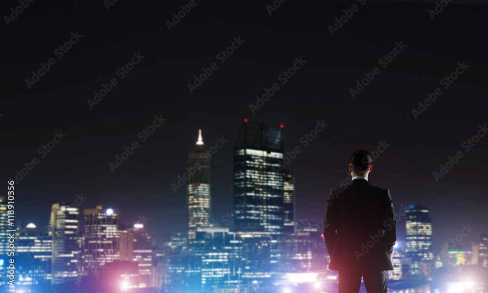 Businessman viewing night glowing city