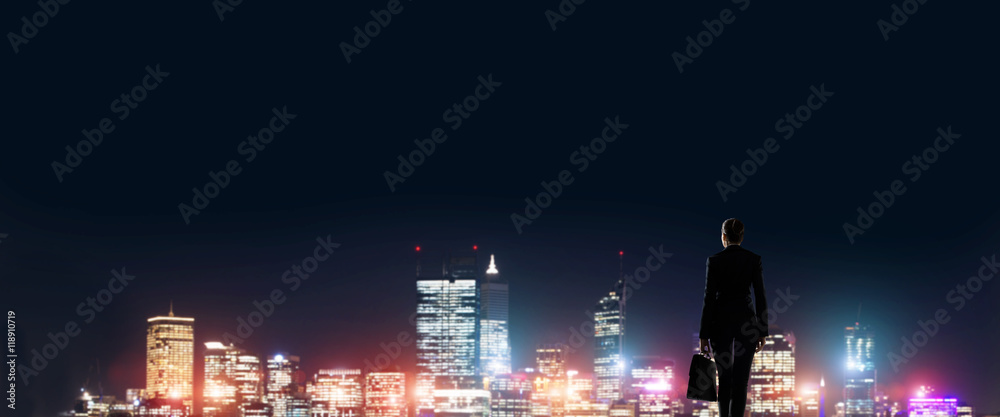 Businesswoman viewing night glowing city