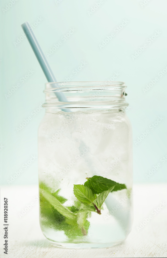 glass of cold water with fresh mint leaves and ice cubes