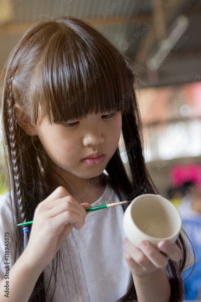 亚洲小女孩用粘土制作的手绘碗