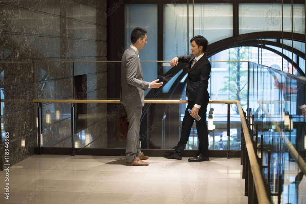 Businessmen have a stand talking in the lobby of the company