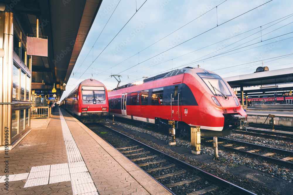 Beautiful railway station with modern high speed red commuter tr