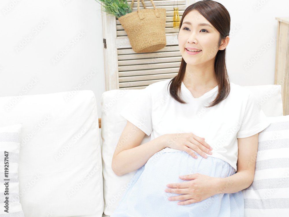 リビングでソファーに座る妊婦　笑顔