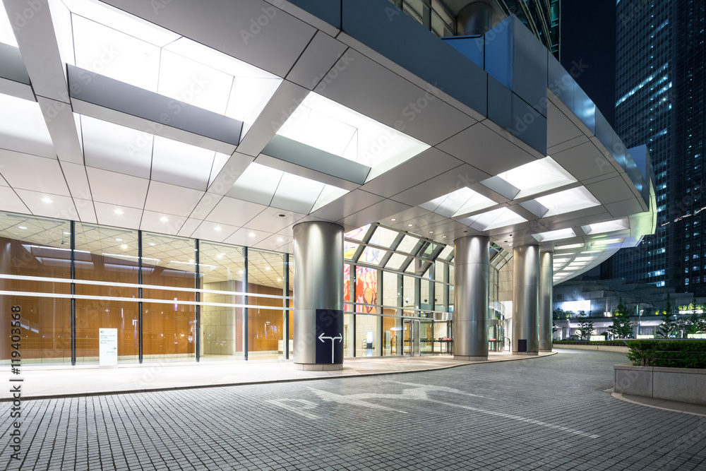 modern buildings in tokyo at night from empty footpath