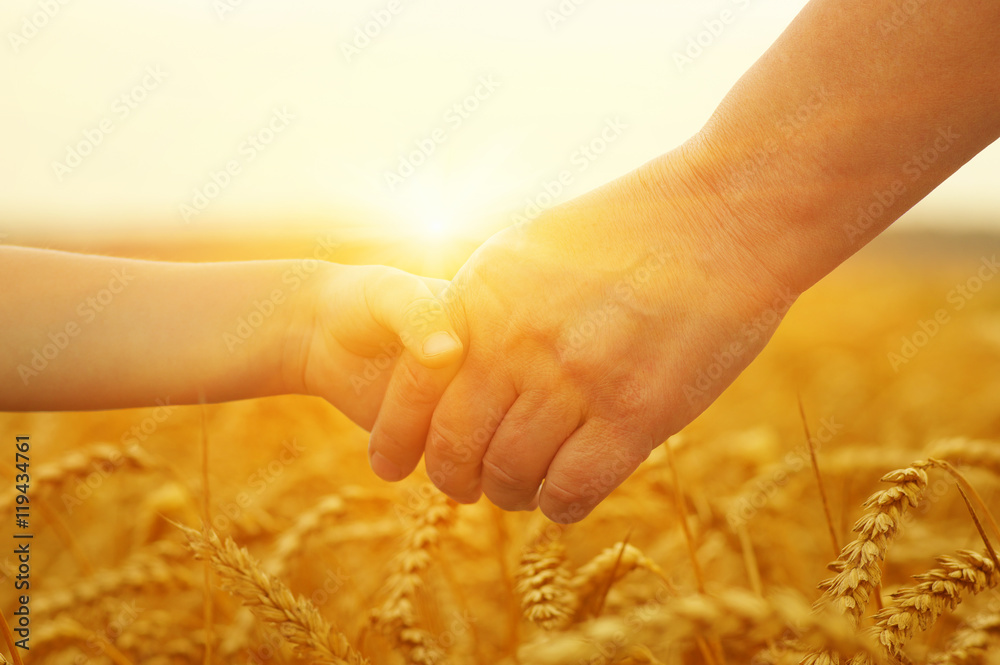 Hands of mother and daughter on sun