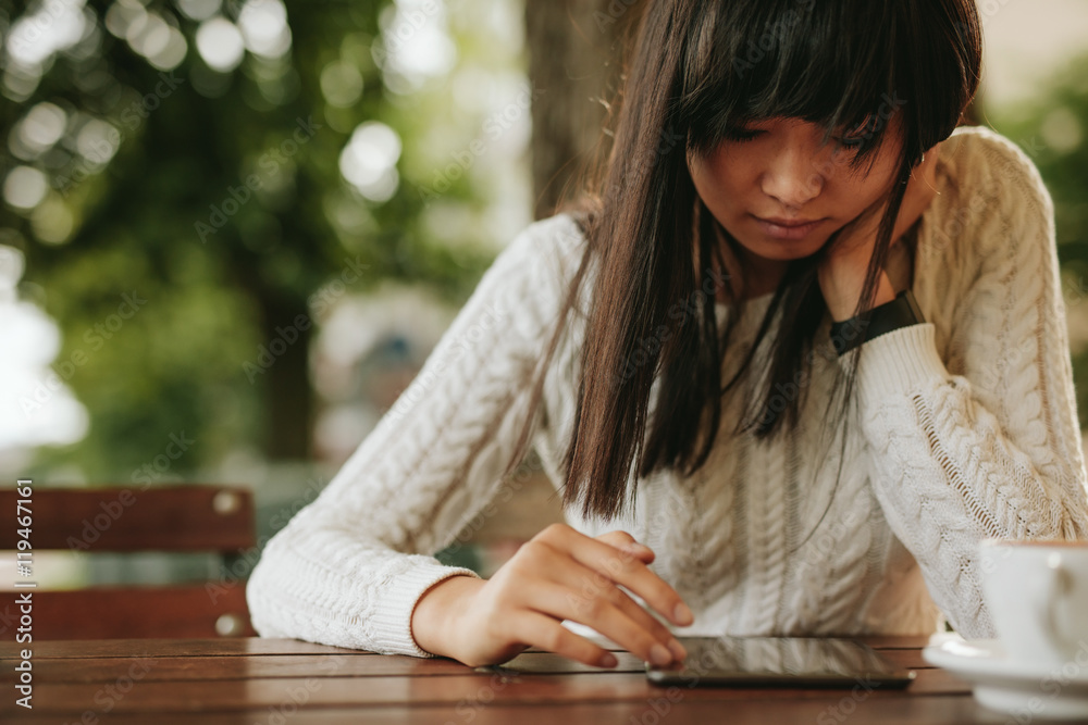 年轻女子在咖啡馆使用数字平板电脑