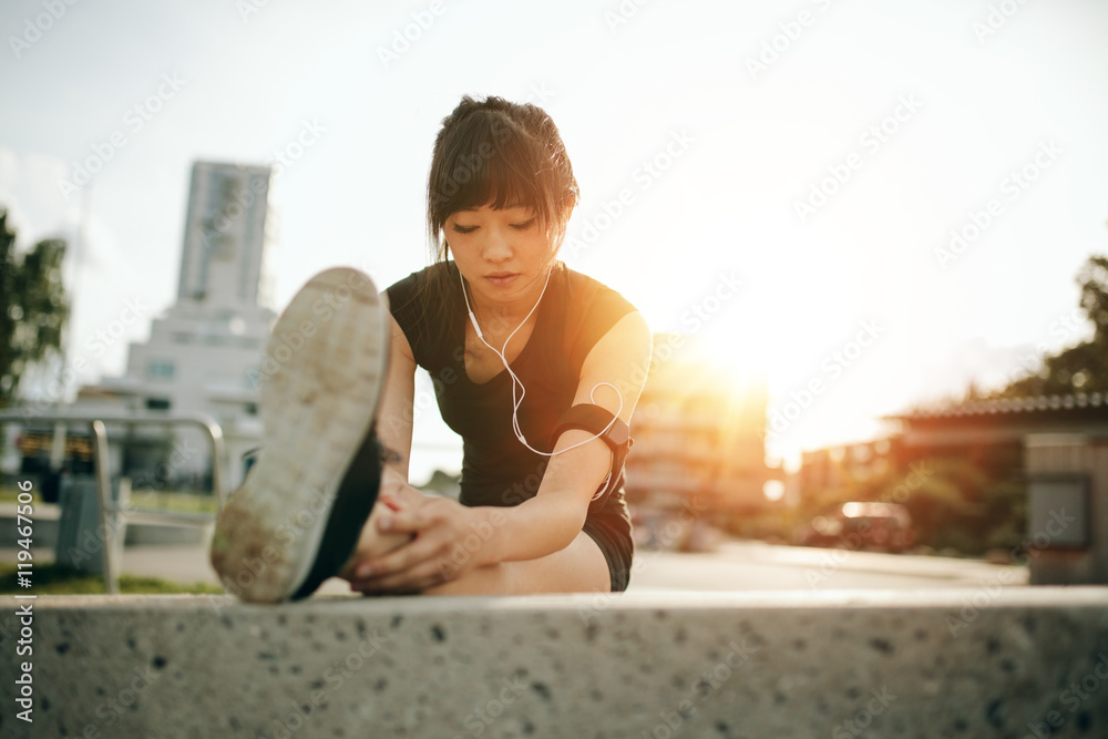 Female runner stretching legs before her workout