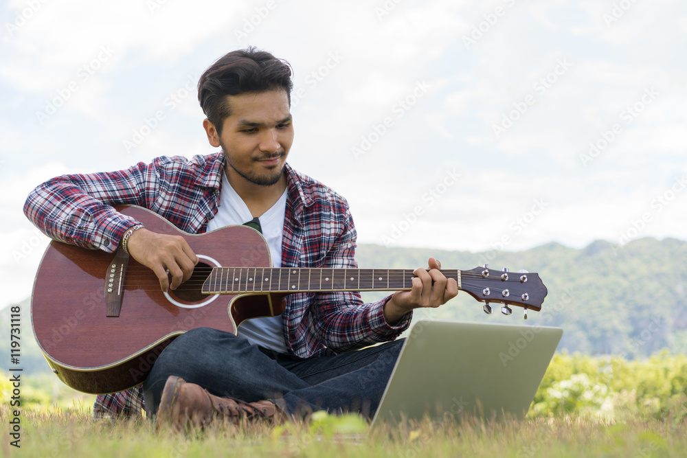 Handsome man smiling, playing guitar