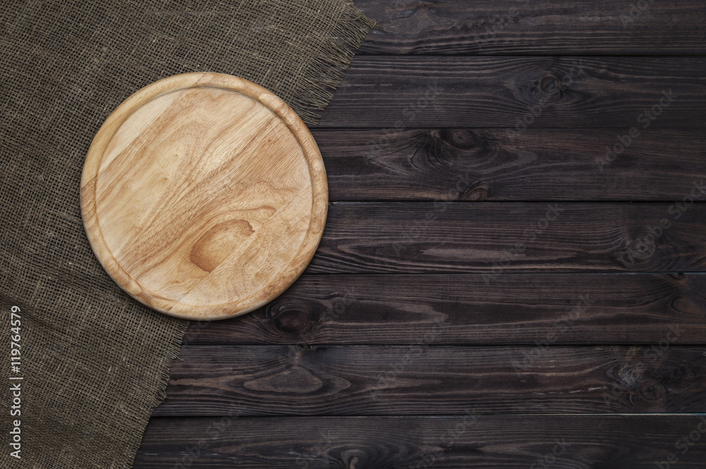 Round cutting board on dark wooden table