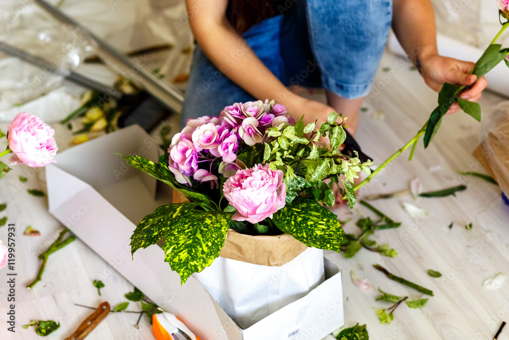 Florist making a bouguet of peonies