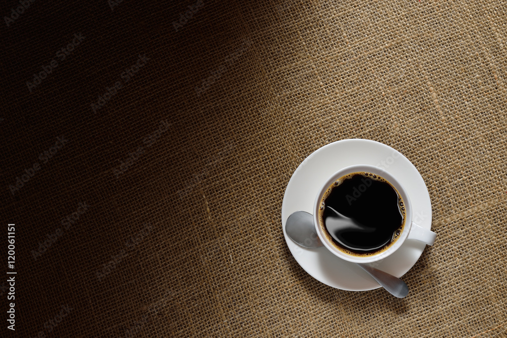 Top view of cup of coffee on burlap background