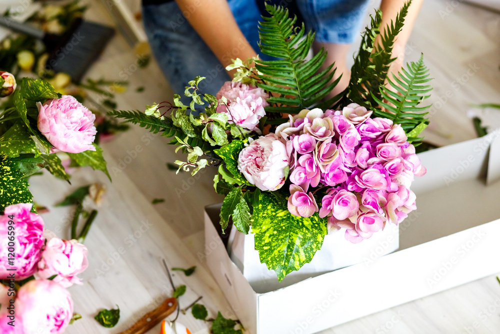 Florist making a bouguet of peonies