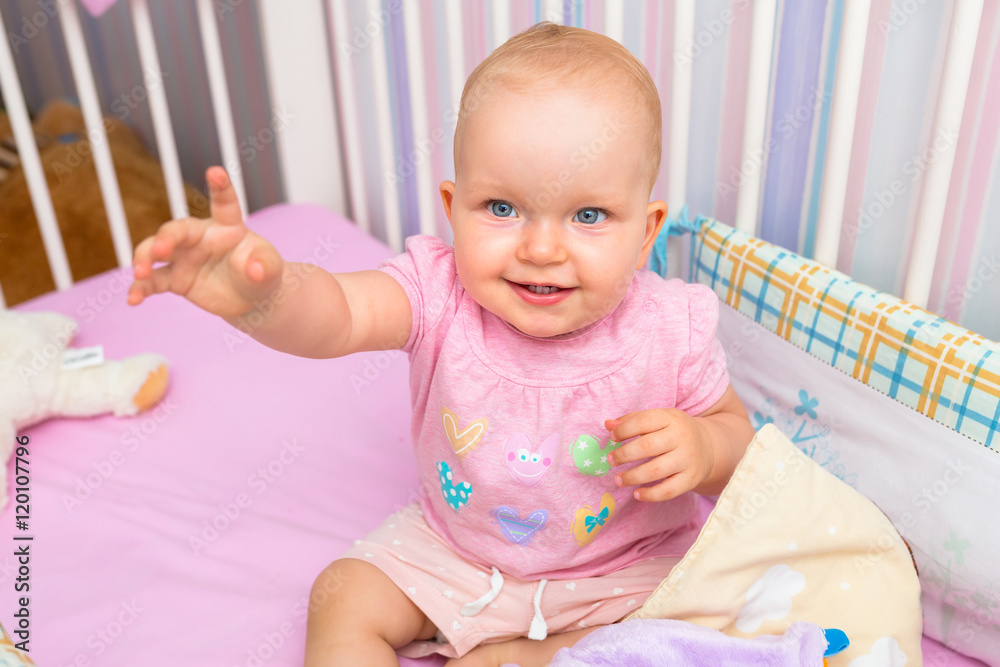 Baby girl sitting in the crib