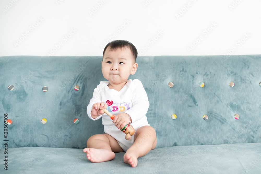 甜蜜的女婴坐在家里的沙发上。