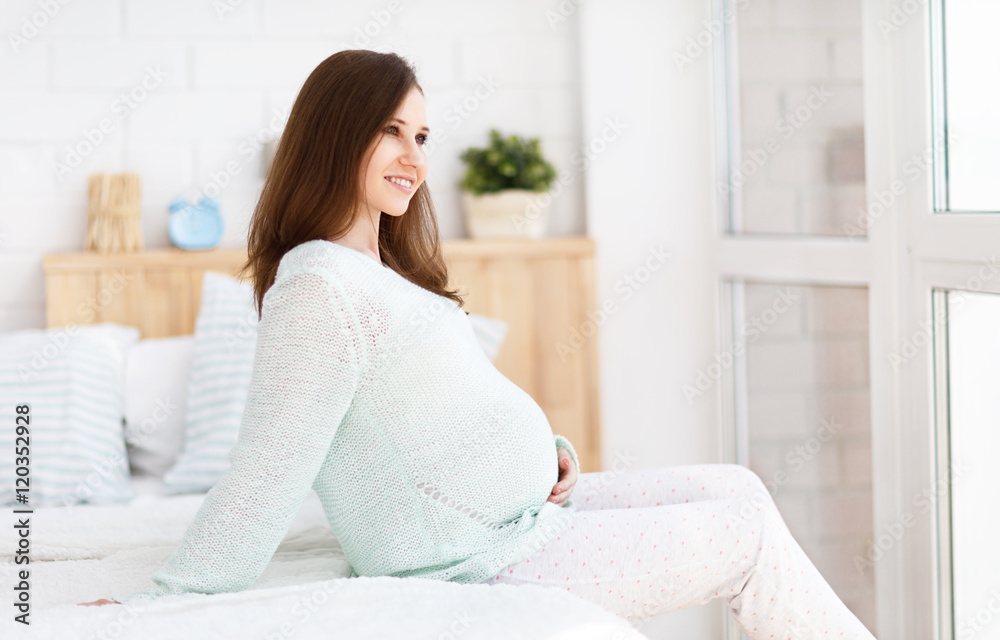 pregnant woman sitting on a bed