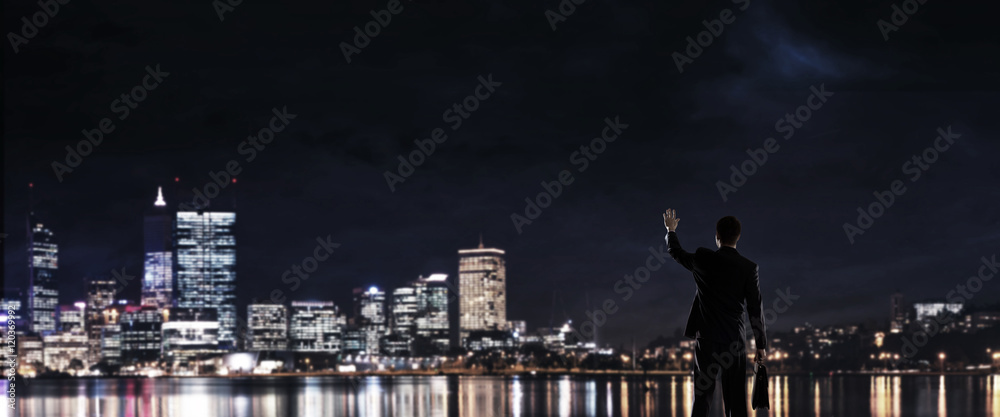 Businessman viewing night glowing city