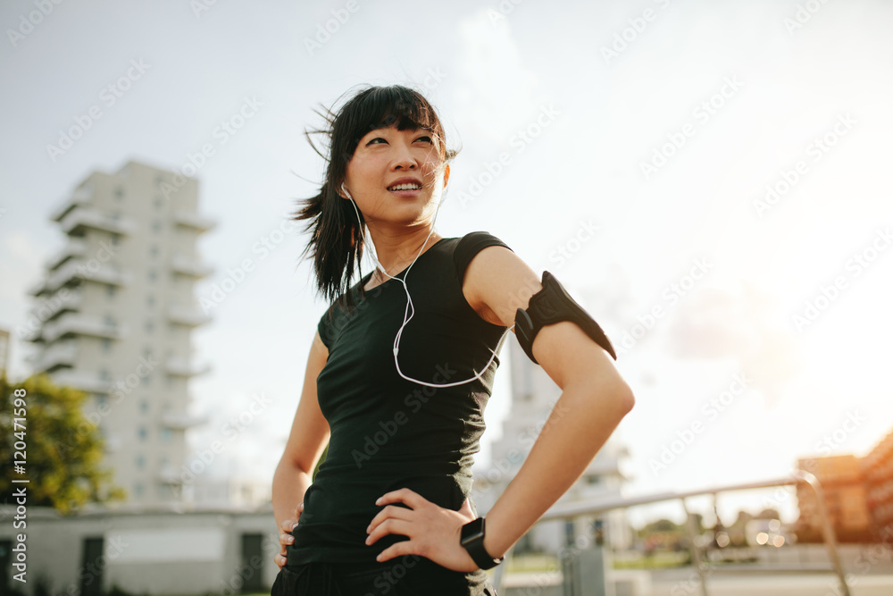 Young woman taking a break during morning run