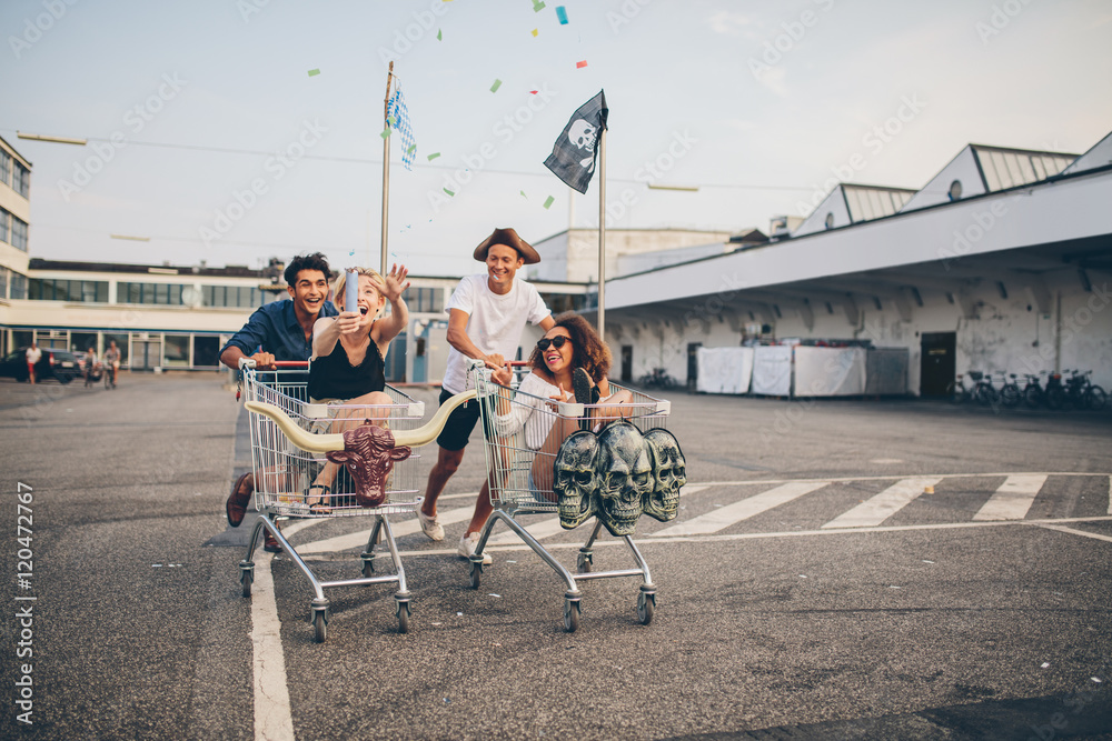 Young friends having fun on a shopping trolleys