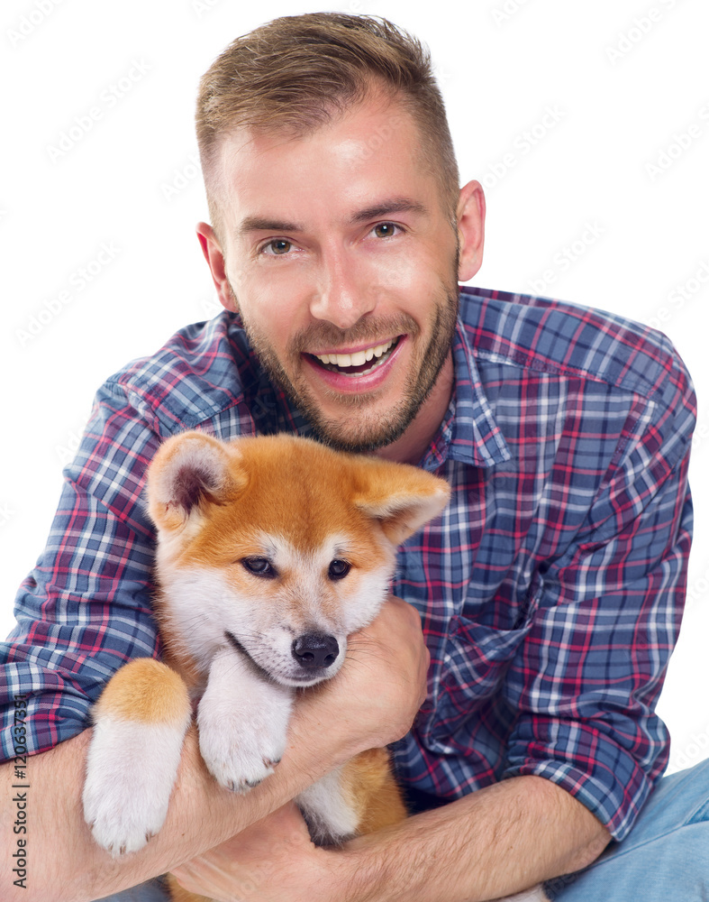 Happy young man with cute little Akita Inu puppy