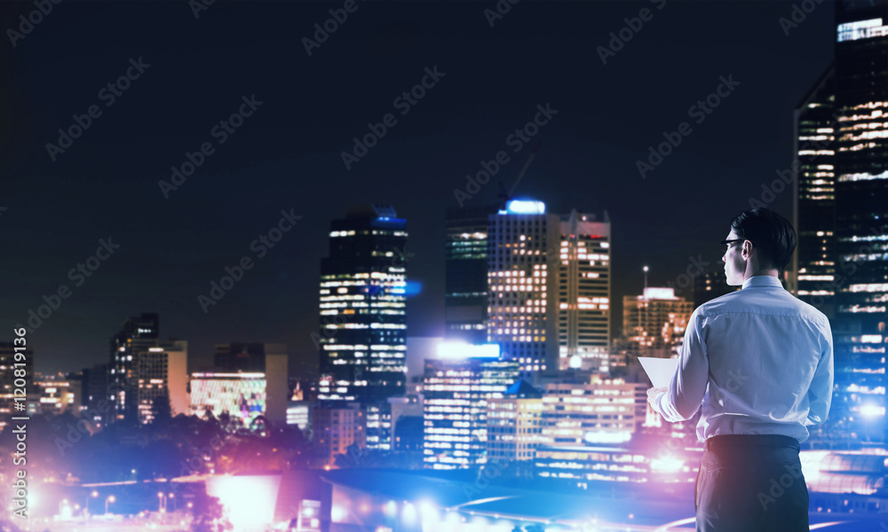 Businessman viewing night glowing city