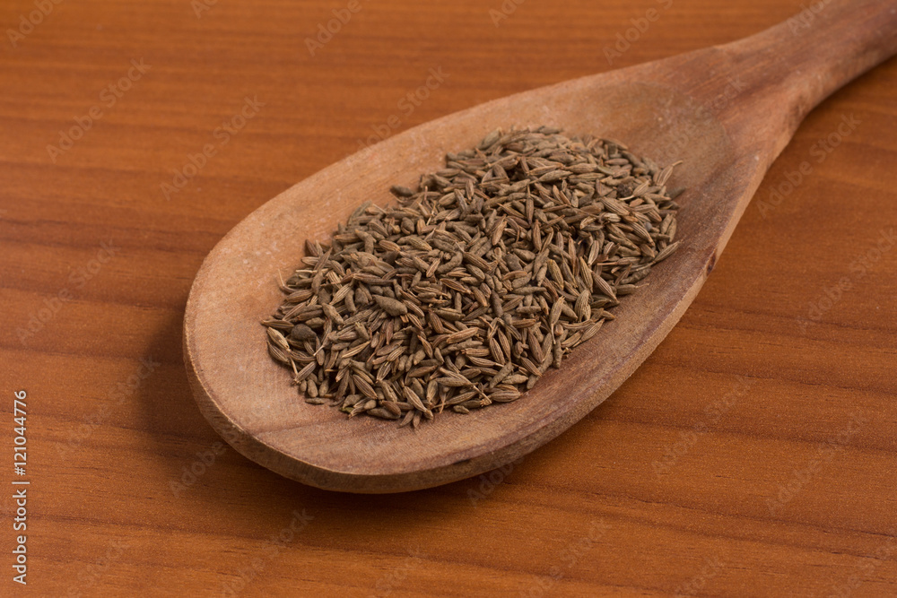 Cumin seeds into a spoon