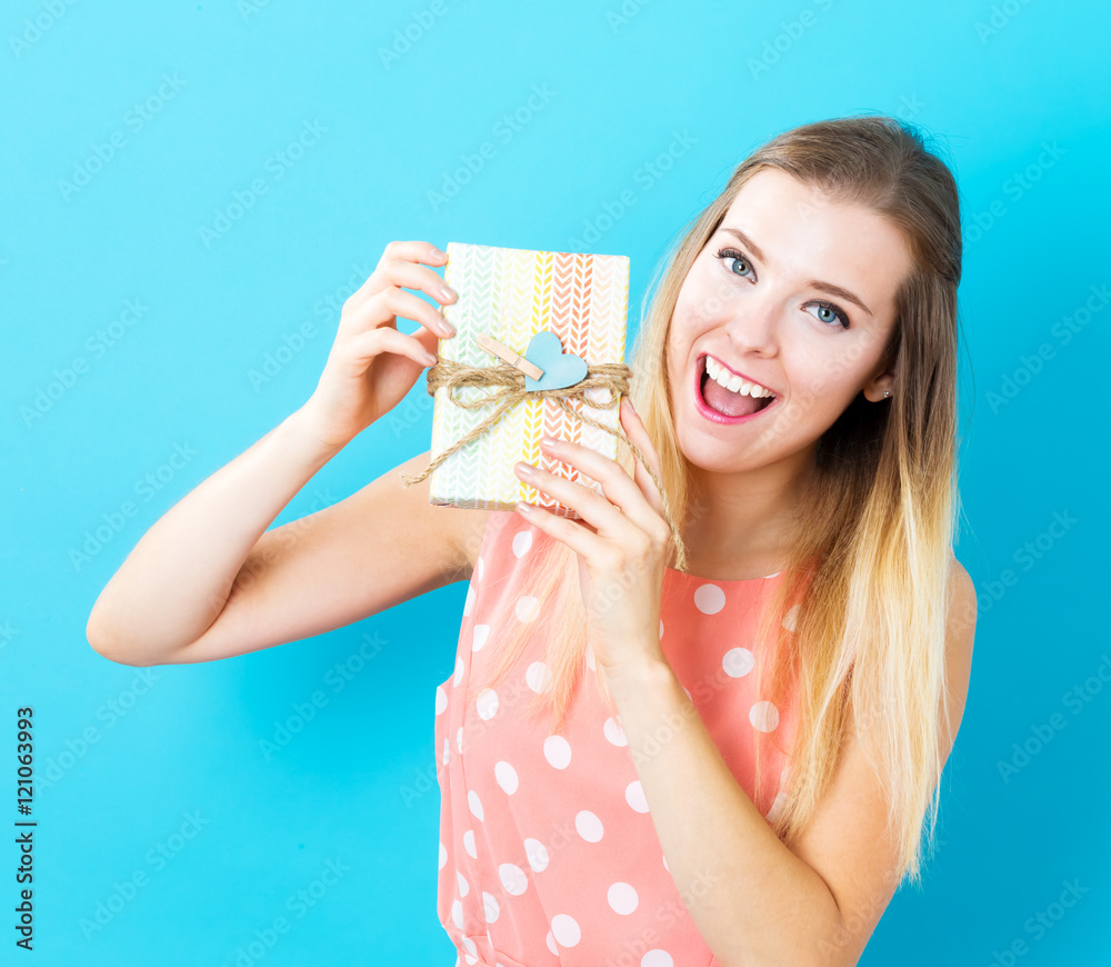 Happy young woman holding a gift box