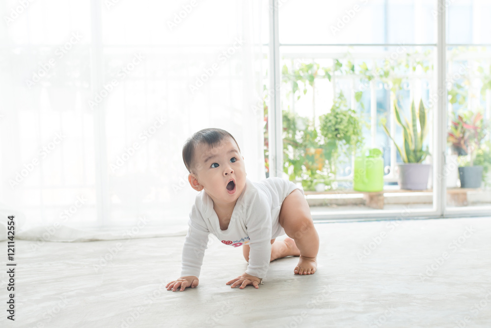 漂亮的小女婴在家里的地板上爬行